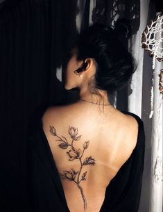 a woman with a flower tattoo on her back