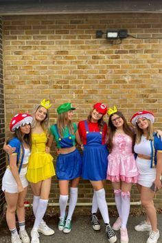 a group of young women standing next to each other in front of a brick wall