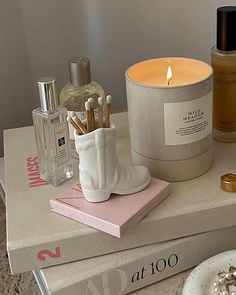 a candle and some other items on top of a box next to a plate with cookies