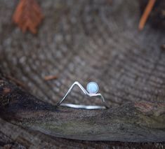 This minimalist Sterling Silver mountain ring is completely handmade by Desiree Rose Jewelry. It is finished off with a beautiful white opal and is simple enough to wear on its own or with other rings. -------- Sizing: -------- This ring was made with high quality round sterling silver wire. It currently comes in sizes 5, 5.5, 6, 6.5, 7, 7.5, 8, 8.5, 9, 9.5 & 10. If you need a different size than what is listed, please send me a message to let me know.  -------------- Ring Meaning: ------------- Dainty White Moon-shaped Jewelry, Minimalist Moon-shaped Adjustable Jewelry, Handmade Silver Opal Moon Ring, Minimalist Moon-shaped Moonstone Ring For Gift, Moon Over Mountains, Silver Moon-shaped Sterling Silver Opal Ring, Ring Meaning, Rings With Meaning, Silver Mountain Ring