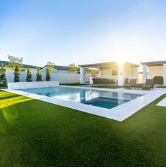 an empty swimming pool surrounded by green grass