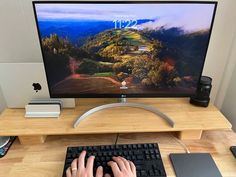 a person is typing on a keyboard at a desk with a computer monitor and mouse