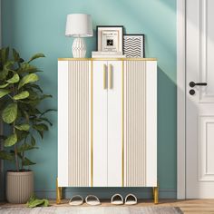 a white cabinet sitting next to a potted plant