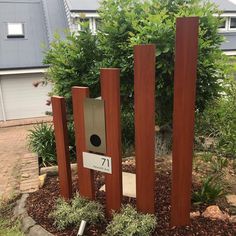 a bird house in the middle of some bushes and trees with a number seven sign on it