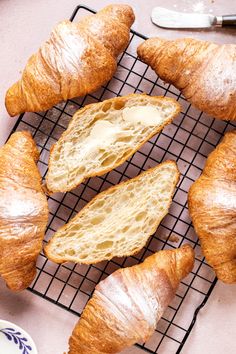 several croissants on a cooling rack with butter