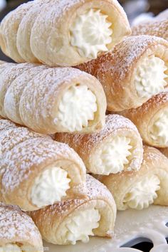 a pile of cream filled pastries sitting on top of a white plate