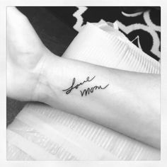 a woman's arm with the word love mom tattooed on her left side forearm