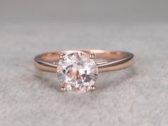 a close up of a ring with a diamond in it on a white cloth background