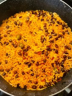 a pan filled with rice and beans on top of a stove