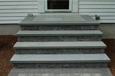 a set of steps leading up to a window on a house's front porch