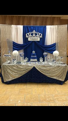 the table is set up with blue and white decorations on it, including an elaborate crown