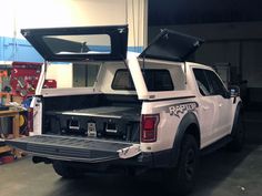 the back end of a white truck in a garage