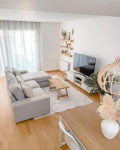 a living room filled with furniture and a flat screen tv sitting on top of a wooden table