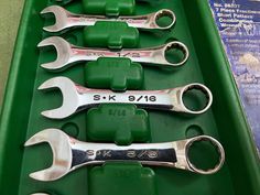 five wrenches in a green tray with the numbers six and seven on them