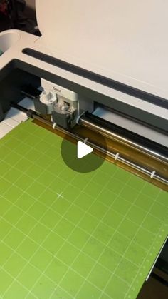 a green cutting mat being used to cut fabric