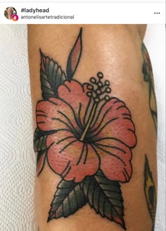 a flower tattoo on the leg is shown in this photo, it appears to be pink and green