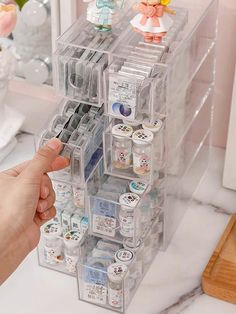 a person holding a plastic container filled with various items in front of a counter top