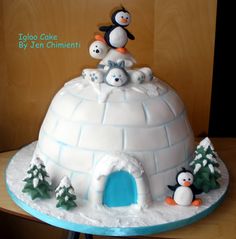 an igloo cake with penguins on top