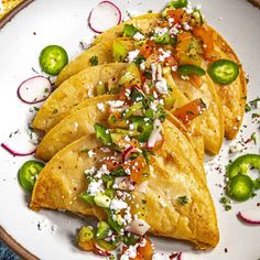 three quesadillas on a white plate topped with sliced jalapenos