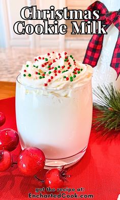 a close up of a drink in a glass on a table with christmas decorations around it