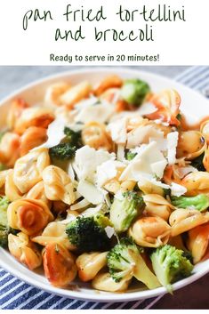 a white bowl filled with pasta and broccoli on top of a blue striped table cloth