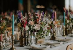 there are many vases with flowers in them on the table at this wedding reception