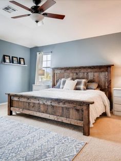 a bedroom with a bed, dresser and ceiling fan in the middle of the room