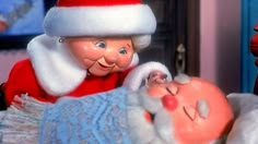 a santa clause is laying in bed with a baby