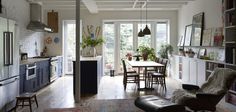 a living room filled with furniture and a dining table next to an open kitchen area