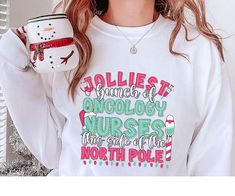 These Christmas Oncology Nurse Sweatshirts are soft and cozy, perfect for everyday.  They make a great gift for RN grad gifts, coworker department gifts and of course nurse appreciation gifts!  G O O D   T O   K N O W ♥Shirts sold SEPARATELY ♥All items are made to order ♥They will ship within one week from one of our printing partners. Please allow sufficient time for production and shipping. P R O D U C T   &  P R I N T I N G ♥Gildan Brand Crewneck Sweatshirt ♥Poly Cotton Blend ♥No side seams for a more flattering (and not scratchy) look and feel ♥Rolled sleeves in photos are for styling purposes only ♥Props used in photo are not included ♥This is a direct to garment printing  ♥The print is printed into the fabric, not sitting on top of it Our designs are printed using the highest quality Oncology Nurse, Jolliest Bunch, Oncology Nursing, Nurse Appreciation Gifts, Nurse Christmas, Nurse Sweatshirt, Nurse Appreciation, Rolled Sleeves, Grad Gifts