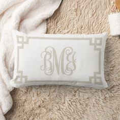 the monogrammed pillow is next to a white blanket