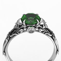 Beautifully crafted Edwardian vintage style filigree skull engagement ring. This ring features  a 6.5mm round Lab emerald center stone, with round diamond accent stones hidden beneath. Antiqued finish to show detail. Message us about a custom idea!  To see my collection of Skull themed rings, click here: https://www.etsy.com/shop/MetalWendler?ref=seller-platform-mcnav&search_query=skull Engagement Ring:  ● Band is 5.6mm at widest point of Floral Filigree, then tapers down to 2.5mm at the back of Engagement Ring Alternative, Gothic Engagement Ring, Skull Engagement Ring, Floral Filigree, Claw Ring, Alternative Engagement Rings, 1 Carat, Vintage Stil, Ring Verlobung