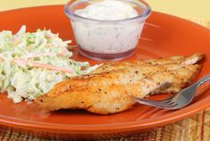 a plate with chicken, coleslaw and a small bowl of ranch dressing on it