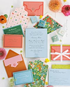 the wedding stationery is laid out on top of each other, including cards and envelopes