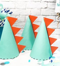 three paper trees are on a table with confetti cones in the shape of animals