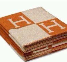 four orange and white napkins stacked on top of each other with the letter h