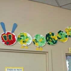 the very hungry caterpillar paper plate craft is hanging on the wall above the door