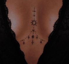 the back of a woman's chest with an arrow and stars tattoo on it