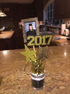 a table with a vase filled with gold confetti and a photo on it