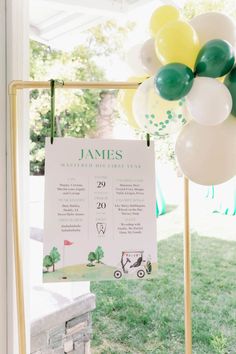 a table with balloons and a sign on it