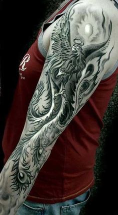 a man with a full sleeve tattoo on his arm and shoulder is shown in black and white