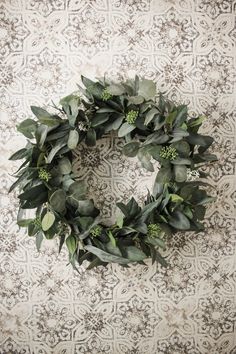 a wreath with green leaves on a wall