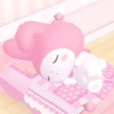 a hello kitty doll laying on top of a pink bed