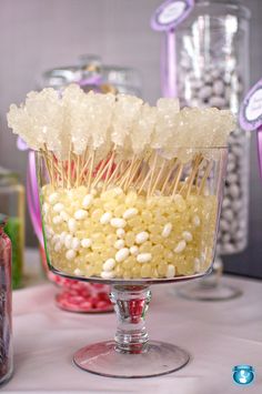 there are many candies in a glass bowl on the table with other candy items