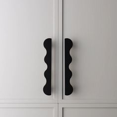 two black handles on white cabinets in a room