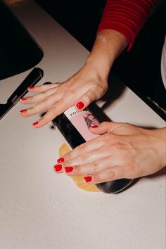 a woman with red nail polish holding onto a cell phone