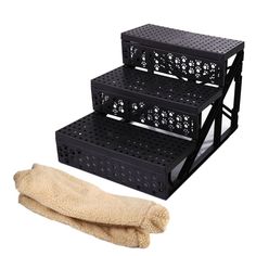 three tiered rack with two pairs of gloves next to it on a white background