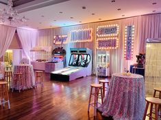 a room filled with tables and chairs covered in pink tablecloths next to a bowling alley