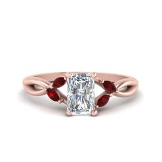 a cushion cut diamond ring with three red stones on the band