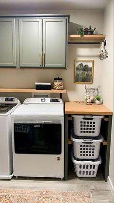 a washer and dryer in a small room next to some shelves with baskets